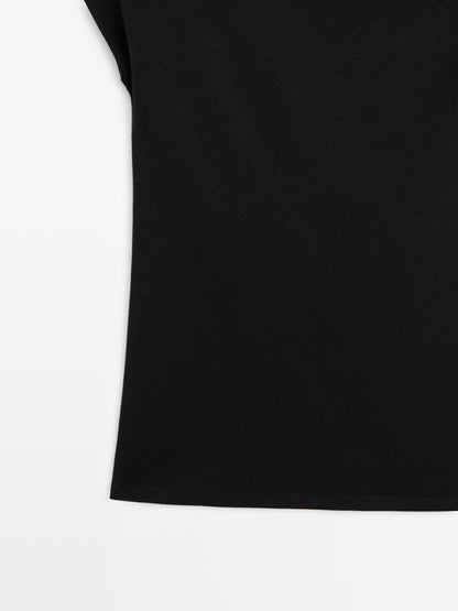 Sleeveless draped top with shoulder applique